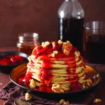 stack of pancakes with strawberry jam and walnuts. tasty dessert
