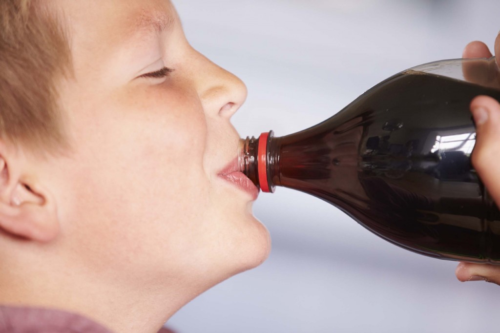 Close Up Of Boy Drinking Soda From Bottle