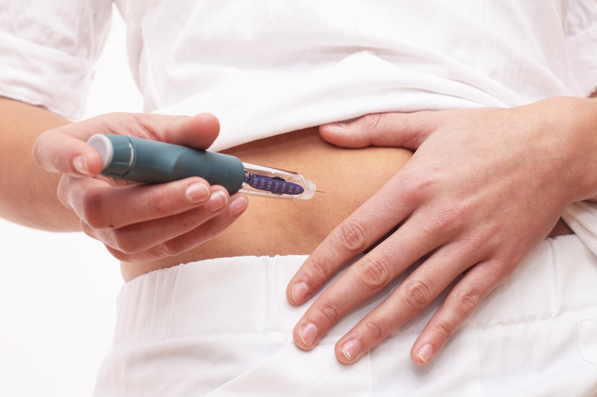 Young woman is injecting Insulin with a Insulin Pen