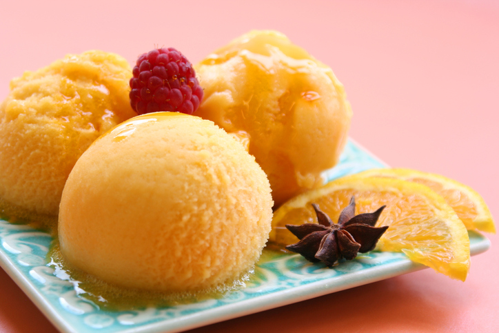 Orange sorbet served on a plate with slices of orange