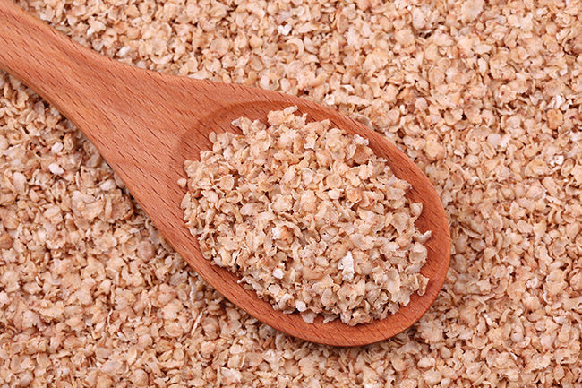 Instant buckwheat flakes in a wooden spoon