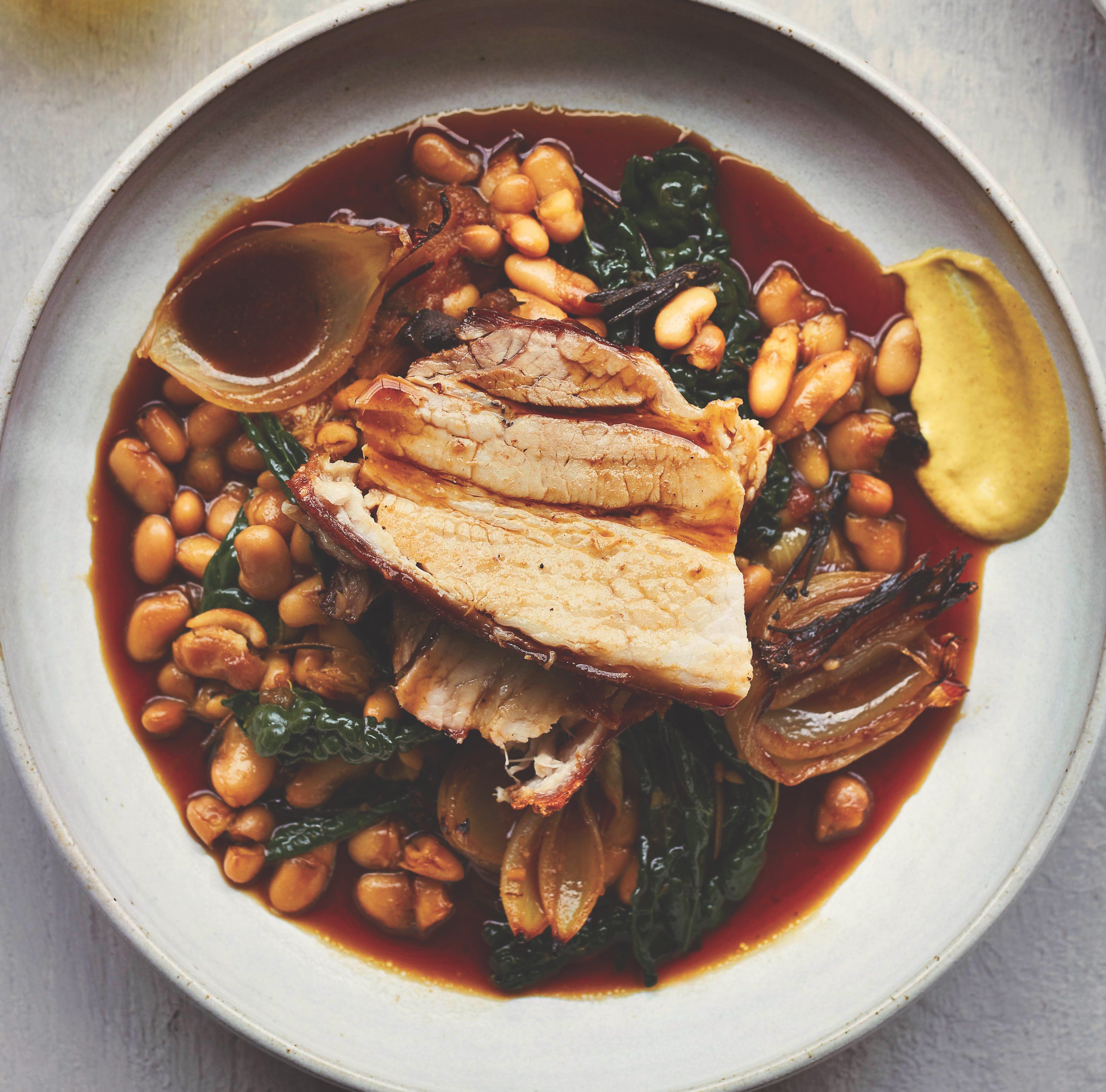 Slow-roasted pork belly with cannellini beans recipe