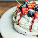 Vegan pavlova, with a boozy cherry sauce